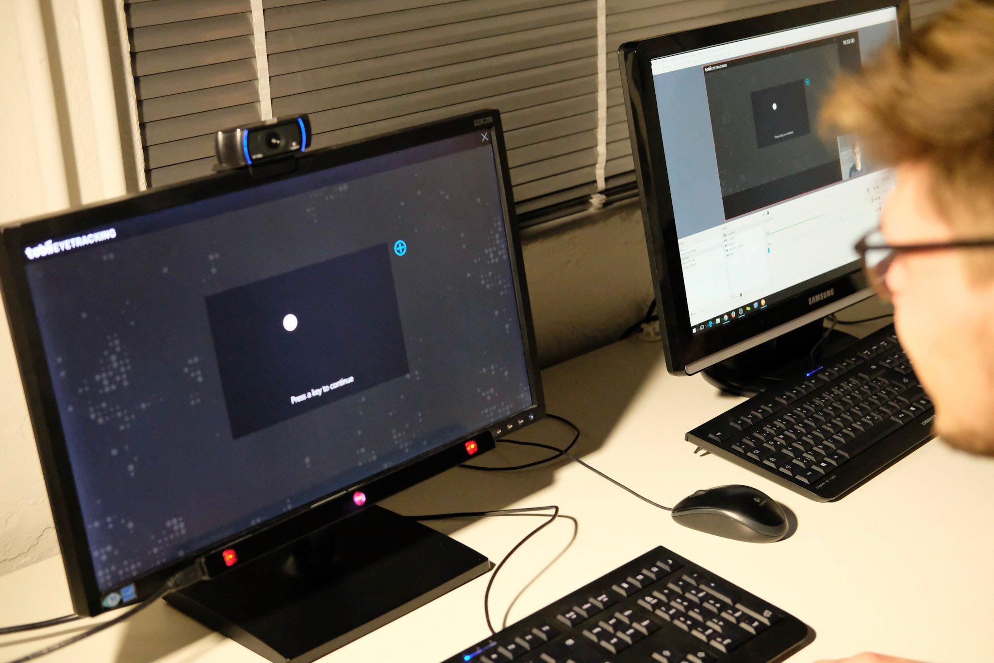 Eine Testperson sitzt vor einem Bildschirm, auf dem das Eye Tracking kalibriert wird.