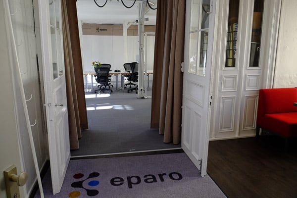 Eingangsbereich vom eparo Workshopraum, weiße Doppeltür geöffnet, eparo logo auf Teppich.